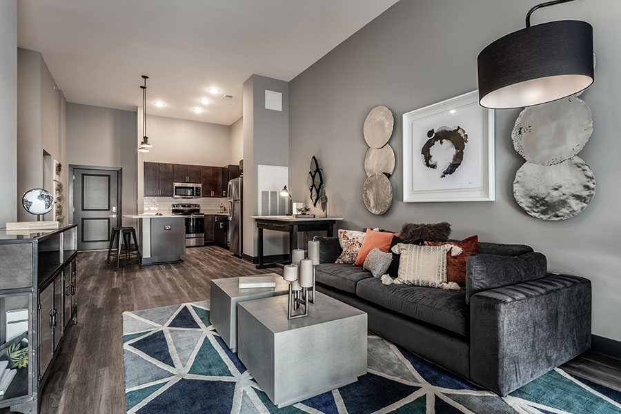 A gray living room and kitchen at Spark Apartments