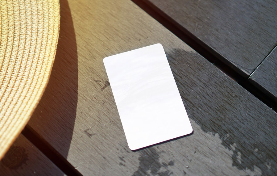 Don't forget your pool pass to to take a refreshing swim at City Flats on Tenth. Summer hat and key card on a deck floor.