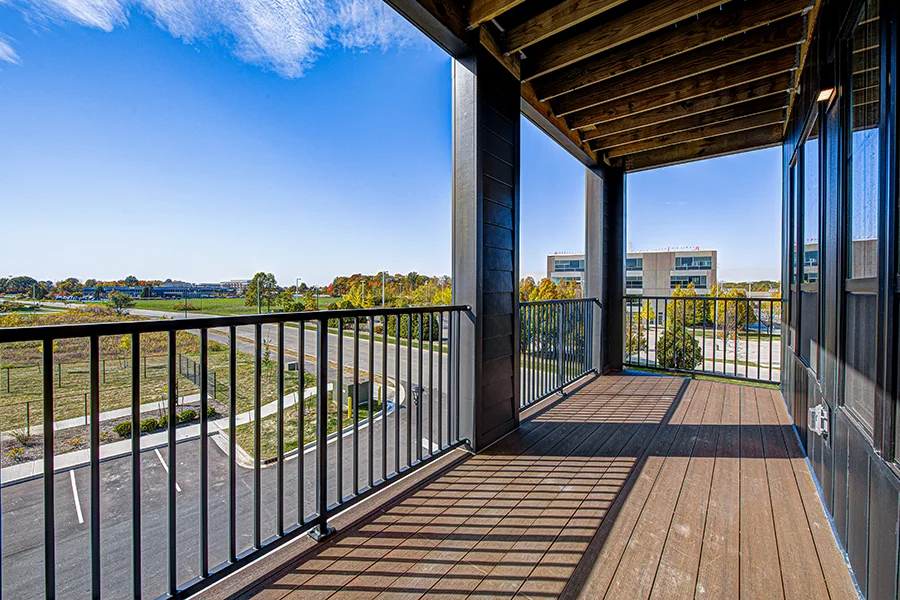 Take in the view like this one at The State at Fishers Apartments and ask about nearby attractions. A view from a balcony at The State at Fishers looking toward the surrounding community